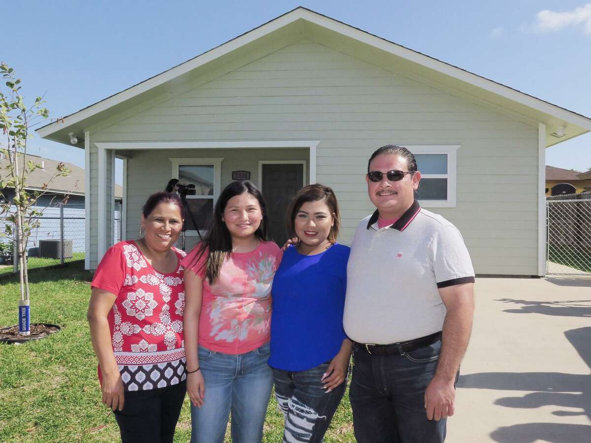 Maria and Jose Lopez and their daughters Michelle and Daniela Padron pose outside the new home presented to the family by Habitat for Humanity-Laredo-Webb County representatives Wednesday, July 19, 2017.