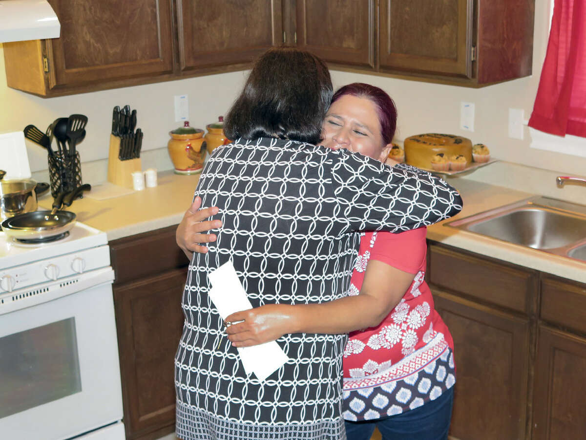 Maria Lopez is overcome with emotion as she is embraced by Habitat for Humanity-Laredo-Webb County Executive Director Carol Sherwood after receiving the keys to her new home in the Sierra Vista Subdivision, Wednesday, July 19, 2017.
