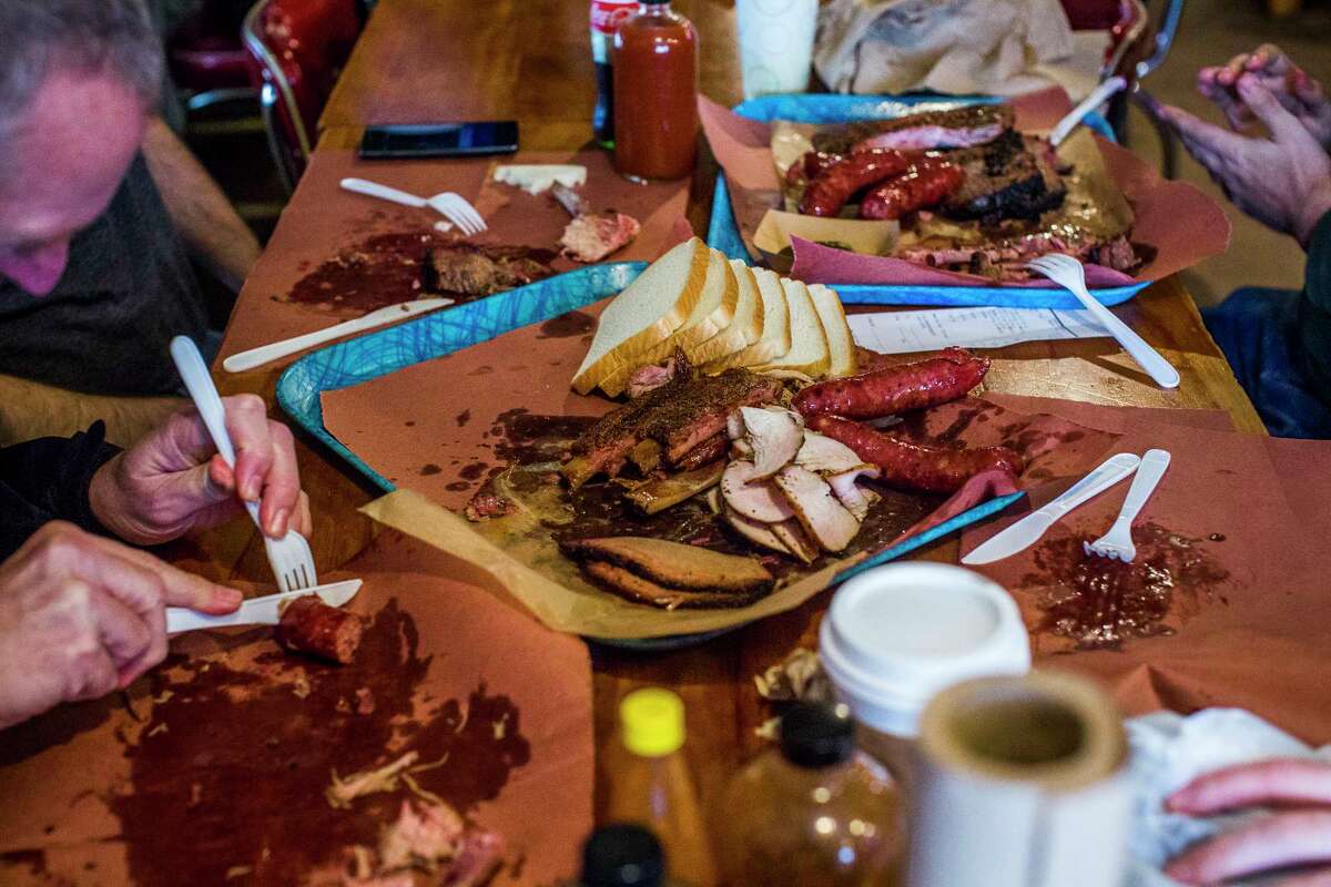 Barbecue fans digging into Franklin Barbecue smoked meats. The barbecue joint, damaged in a fire in August, reopened Nov. 21.