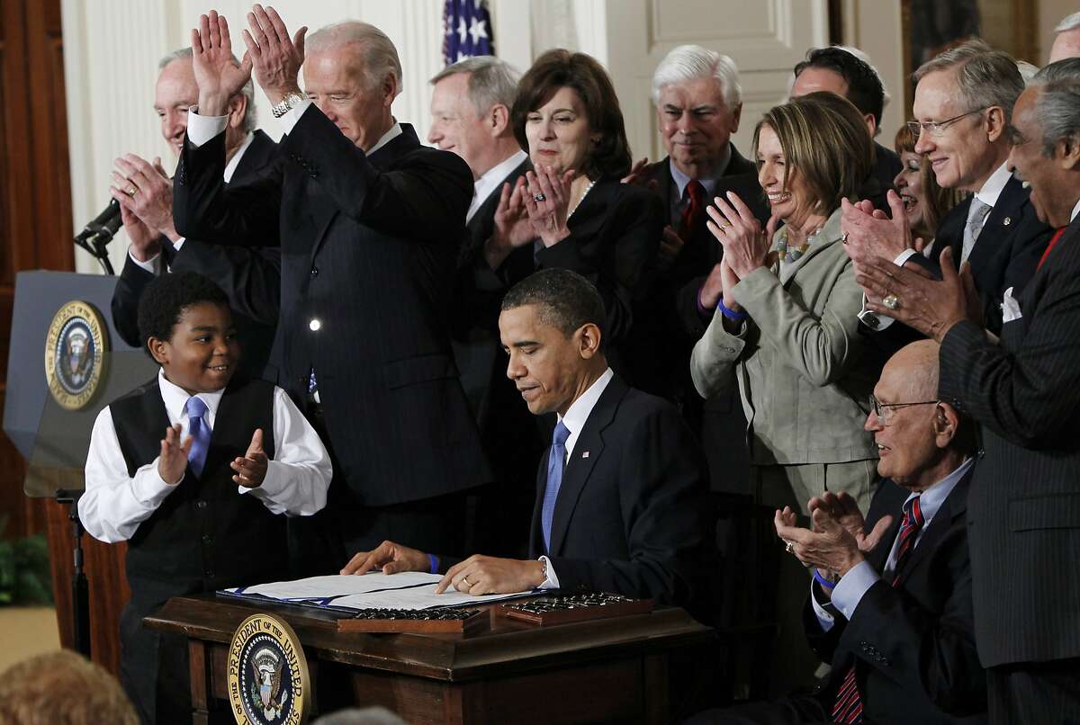 FILE -In this March 23, 2010, file photo President Barack Obama is applauded after signing the Affordable Care Act into law in the East Room of the White House in Washington. If the law survives Supreme Court scrutiny, it will be nearly a decade before all its major pieces are in place, and even if he is re-elected, Obama won't be in office to oversee completion of his biggest domestic policy accomplishment, assuming Republicans don't succeed in repealing it. The law's carefully orchestrated phase-in is evidence of what's at stake in the Supreme Court deliberations that start March 26, 2012. (AP Photo/Charles Dharapak, File)