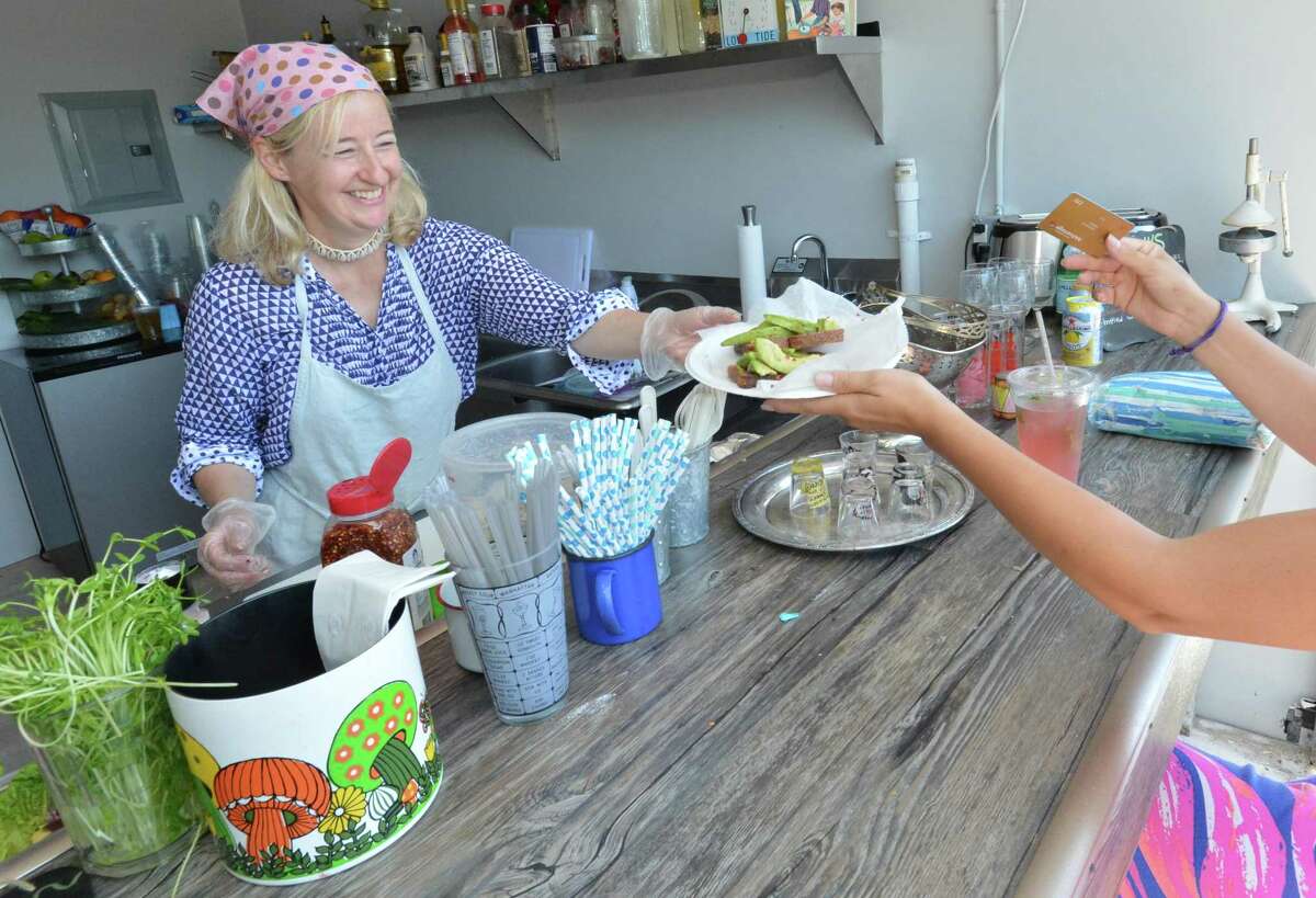 Gina Legnani serves up an avacado on toast sandwich to a customer at her shop Eats and Antiques in Rowayton center on Wednesday July 19, 2017 in Norwalk Conn.