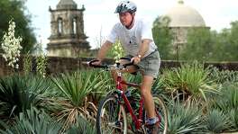 Murphy Emmons, a member of Los Compadres and one-time board chairman, rides his bike near Mission San Jose in 2002.