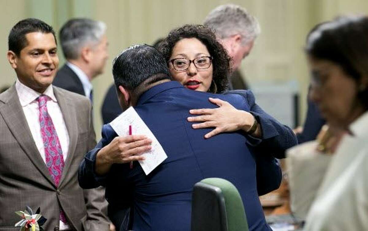 Democratic Assembly members Eduardo Garcia, of Coachella, second from left, and Cristina Garcia, of Bell Garden, second from right, hug after their climate change bills were approved by the Legislature, Monday, July 17, 2017, in Sacramento, Calif. (AP Photo/Rich Pedroncelli)