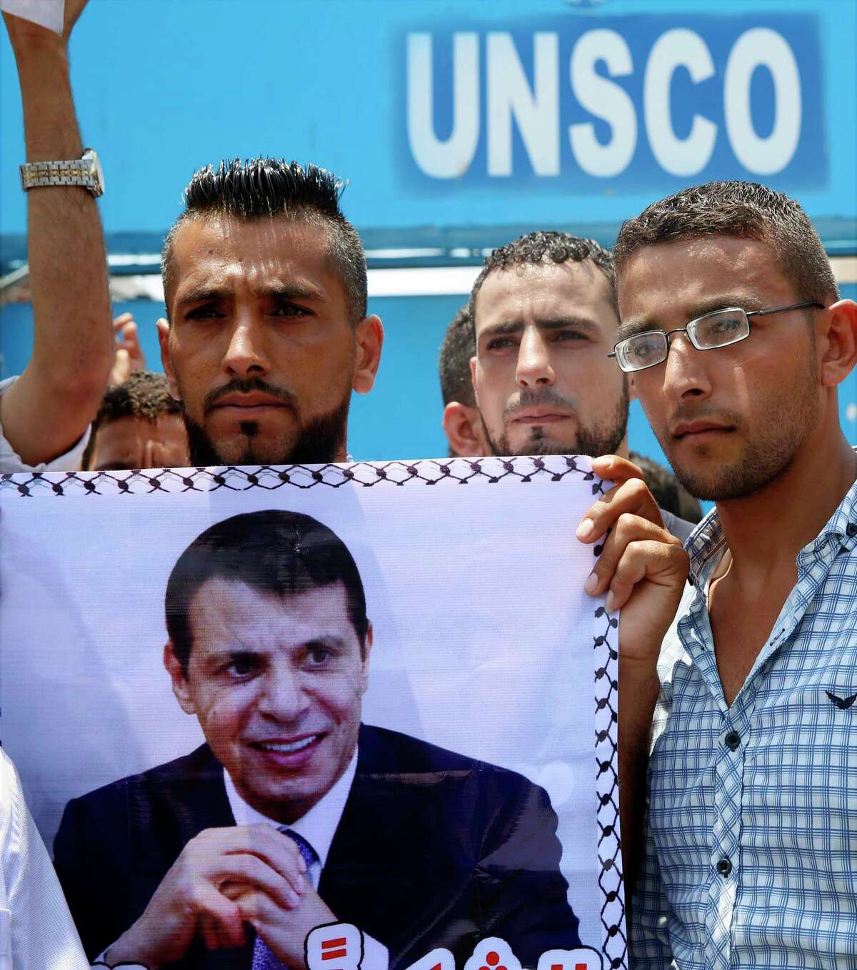 Supporters hold a photo of exiled former Gaza strongman Mohammed Dahlan during a protest against metal detectors that Israel has installed at the Al-Aqsa Mosque compound in Jerusalem, in Gaza City, Thursday, July 20, 2017. A Gaza power-sharing deal between Dahlan and Hamas, two former arch foes, is slowly taking shape on the ground and could lead to big changes in the Hamas-ruled territory, including an easing of a decade-long border blockade. (AP Photo/Adel Hana)