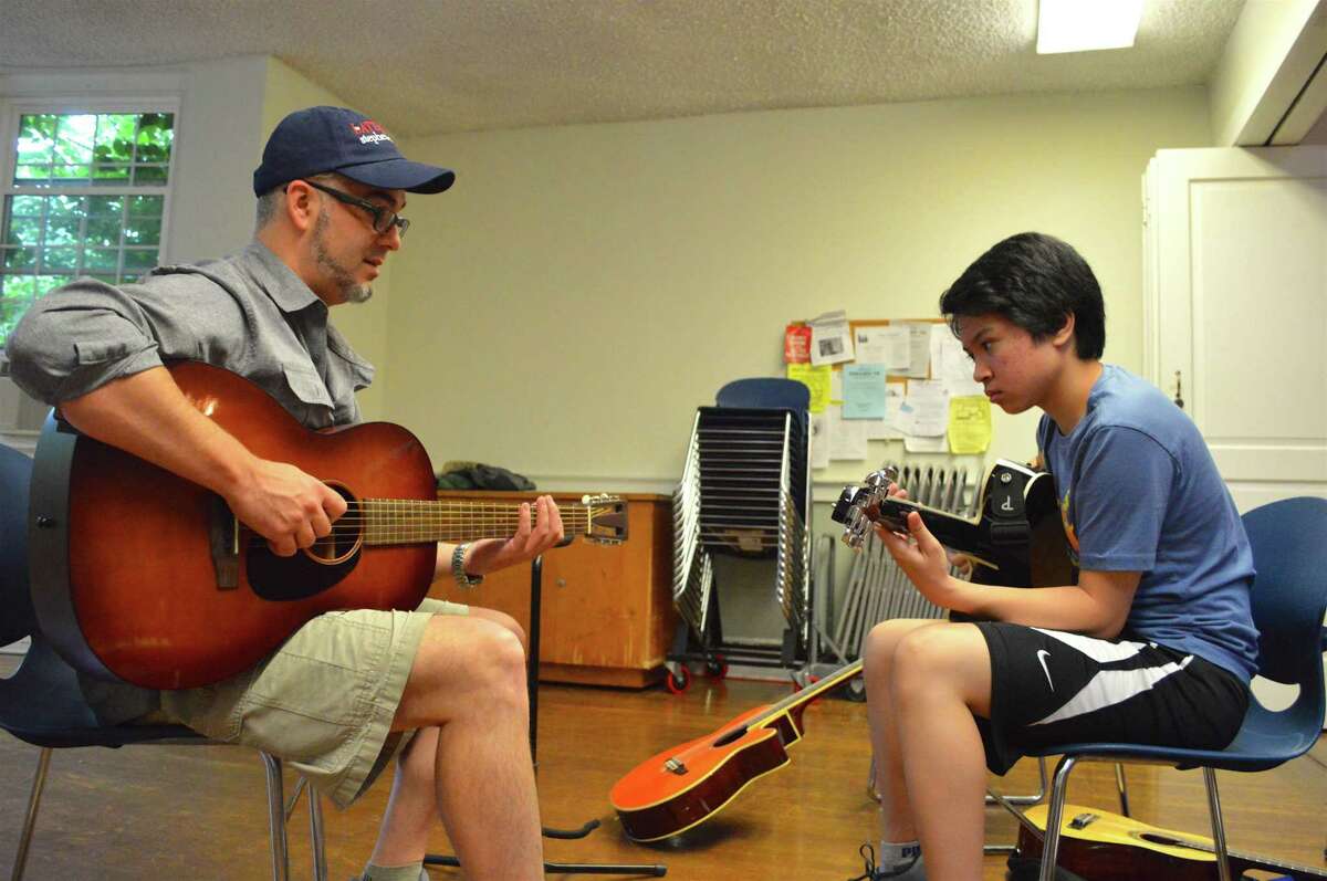 Ben Kibbey, professional musician and music teacher at Saxe Middle School in New Canaan, works with Shawn Ignacio, 14, of Norwalk, at the Rock Out Summer Camp, held at First Congregational Church of Darien through the Parks & Recreation Department, Friday, July 14, 2017, in Darien, Conn.