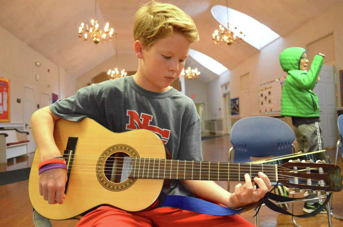 Logan Hickey, 11, of New Canaan, plays a D chord at the Rock Out Summer Camp, held at First Congregational Church of Darien through the Parks & Recreation Department, Friday, July 14, 2017, in Darien, Conn.