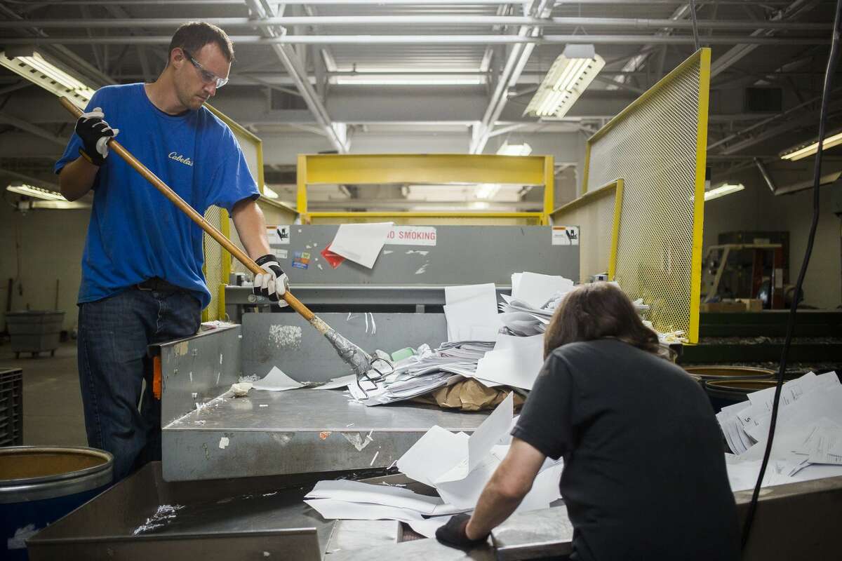 Jacob Balcerak, left, moves paper onto a conveyor belt as part of his recycling job at the Arnold Center on Thursday. The Arnold Center provides services and support to people with disabilities and/or other unique needs.