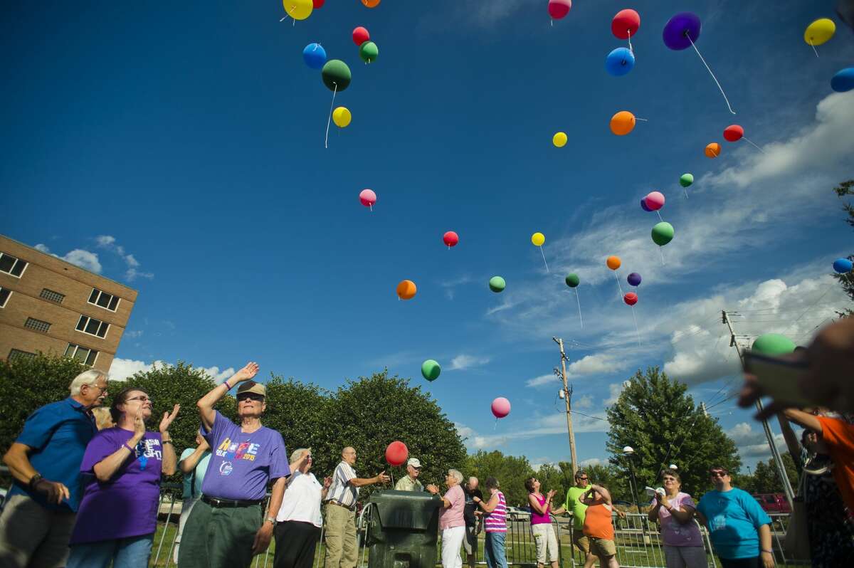 Cancer survivors and their caregivers release balloons during the annual Cancer Services of Midland balloon release on Thursday near The H Hotel.