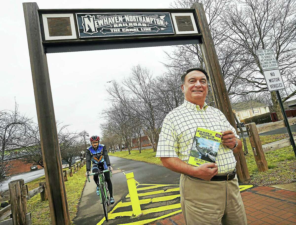 Author Robert Madison photographed with his book, "New Haven and Northampton Canal Greenway: Bike and Rail Trails Following the Histroric Canal" is photographed, Thursday, January 12, 2017, at the Farmington Canal Heritage Greenway on Morse Street in Hamden. The multi-use rail trail started as a waterway, then became a railway and now spans over 80 miles through 16 towns from New Haven to Northampton, Massachusetts. (Catherine Avalone/New Haven Register)