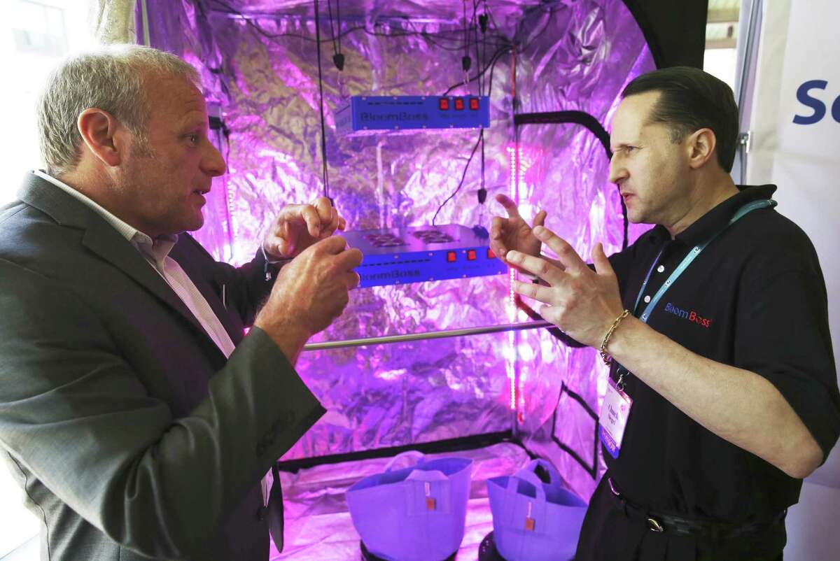 Chuck Siegel (right) describes his product, a grow light system, to Arcview Investor Scot Trifilo as marijuana business investors pitch their ideas to investors at the Arcview Investor Forum at the AT&T Conference and Education Center in Austin on Wednesday, May 3, 2017.