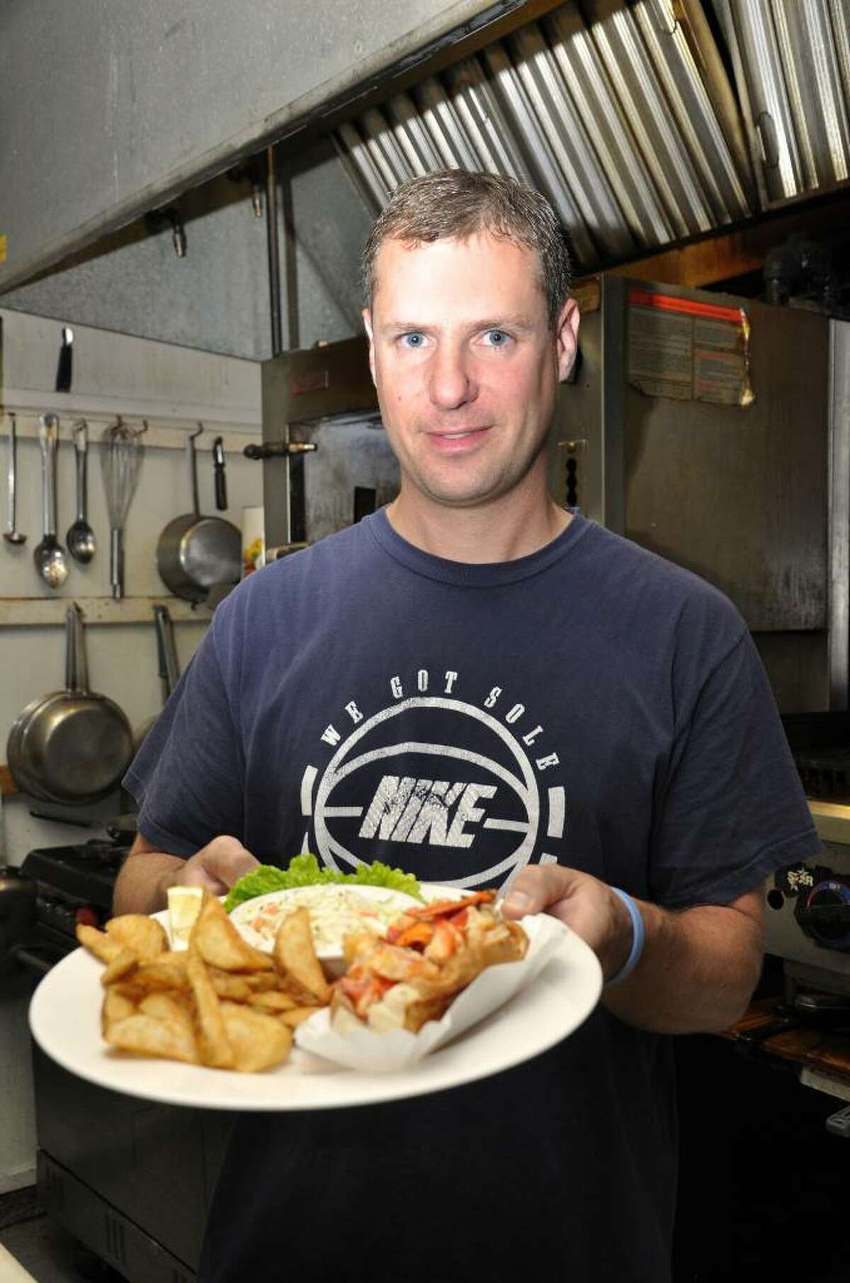 Brent Smith holds a freshly made hot lobster roll on Friday, June 11, 2010 at 7 Seas Restaurant in Milford. Most agree that 7 Seas Restaurant located at 16 New Haven Avenue in Milford makes the best hot lobster roll.