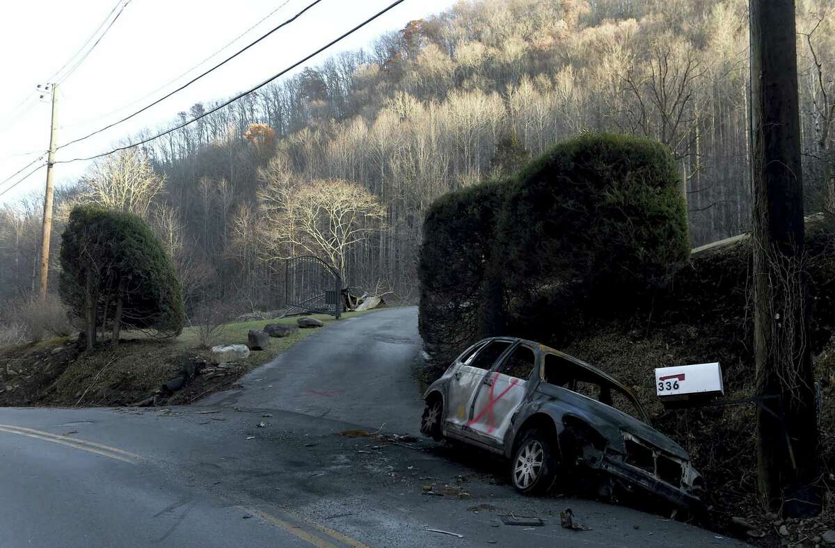 A fire damaged vehicle rest in a ditch in the Roaring Fork area of Gatlinburg, Tenn., Friday, Dec. 2, 2016. Residents on Friday, were getting their first look at what remains of their homes and businesses in Gatlinburg, after a wildfire tore through the resort community on Monday, Nov. 28. (Amy Smotherman Burgess/Knoxville News Sentinel via AP)