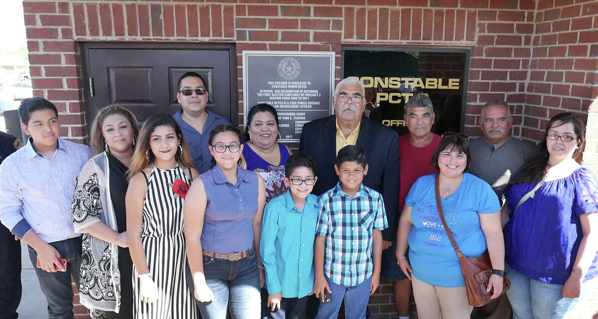 Former Webb County Precinct 2 Constable Ruben Reyes, back row center, and members of his family pose by a plaque dedicating the Constable Precinct 2 Building in honor of Reyes.