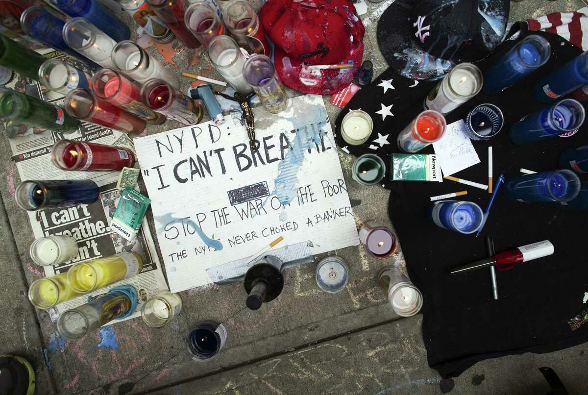 FILE - This July 19, 2014 file photo shows a memorial for Eric Garner on the pavement near the site of his death when taken into custody by police, in the Staten Island borough of New York. Three years after Garner's chokehold death the wheels of justice are turning more slowly than in similar cases. Federal prosecutors have said privately that a decision about whether to charge the police officer seen on video wrapping his arm around Garner's neck is still months away, frustrating the victim's family and leaving the officer's career in limbo. (AP Photo/John Minchillo, File)