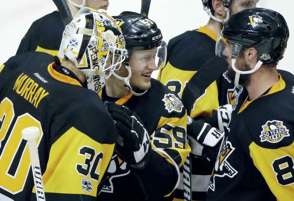 Pittsburgh Penguins’ Matt Murray, left, Jake Guentzel, center, and Brian Dumoulin celebrate after the Penguins defeated the Nashville Predators 4-1 in Game 2 of the Stanley Cup Final, Wednesday in Pittsburgh.