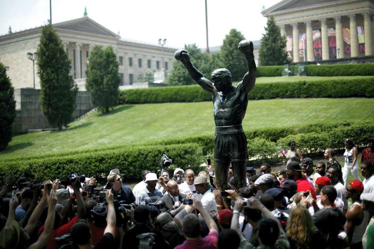 In a Wednesday, June 1, 2011, file photo, boxer Bernard Hopkins, center, and Mayor Michael Nutter, center left, pose for photographs at the base of the Rocky statue in Philadelphia. On Tuesday, May 30, 2017, the city’s Department of Parks and Recreation said the statue will be closed to tourists for two weeks while improvements are being made to the site surrounding the statue at the head of the Benjamin Franklin Parkway.