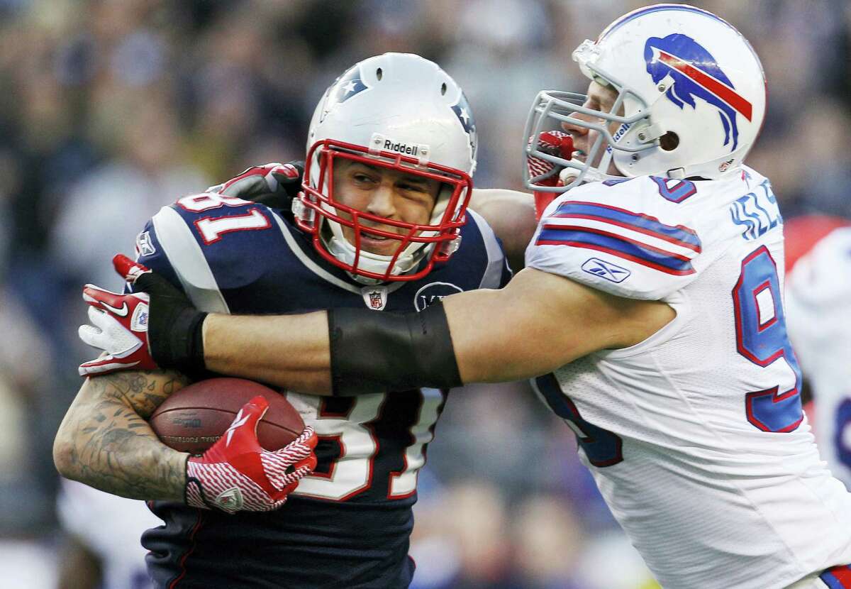 In this Sunday Jan. 1, 2012 photo, New England Patriots tight end Aaron Hernandez (81) tries to break free of Buffalo Bills linebacker Chris Kelsay (90) during the fourth quarter of an NFL football game in Foxborough, Mass. Hernandez, who was serving a life sentence for a murder conviction and just days ago was acquitted of a double murder, died after hanging himself in his prison cell Wednesday, April 19, 2017 Massachusetts prisons officials said.
