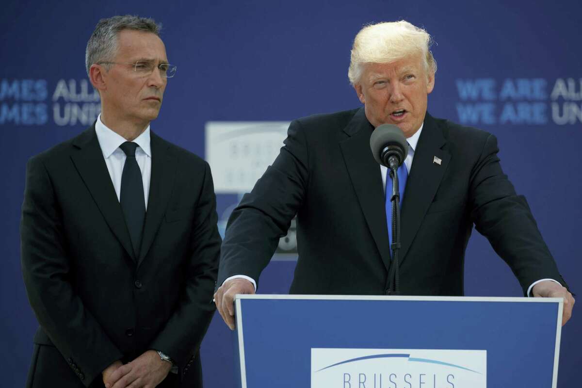 NATO Secretary General Jens Stoltenberg listens as President Donald Trump speaks during a ceremony to unveil artifacts from the World Trade Center and Berlin Wall for the new NATO headquarters, May 25, 2017, in Brussels.