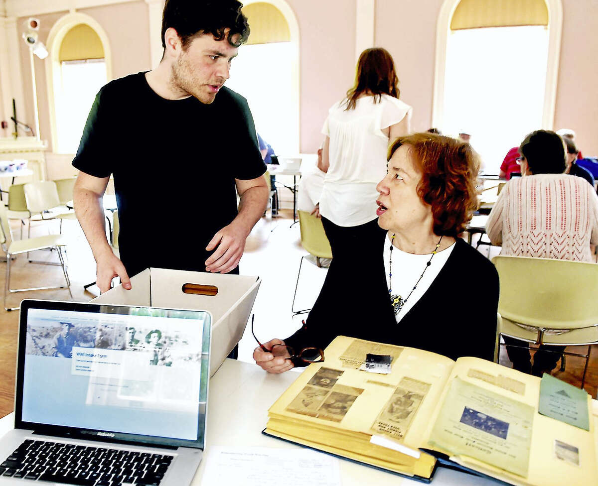 Matt Bonito of the the Connecticut State Library’s “Remembering World War One — Sharing History/Preserving Memories” project, left, speaks with Gail Curran of New Haven during a Digitization Day event at the New Haven Museum in New Haven.