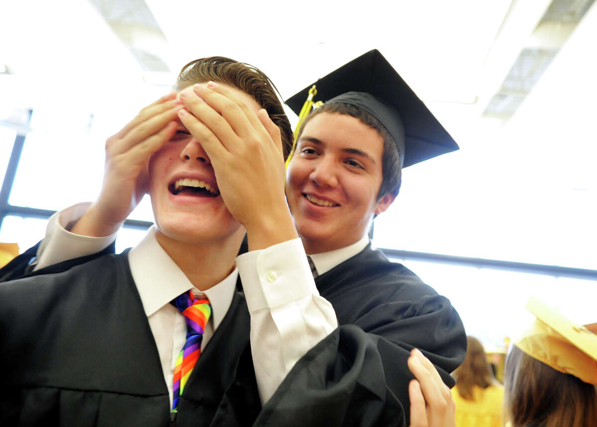 Red Lion Area High School senior Issak Wolfe tries to guess the identity of a friend — fellow senior John Chapman — before the commencement ceremony in 2013. Wolfe, a transgender student, was allowed to wear the boys’ black graduation robes, but his legal, female name was read.