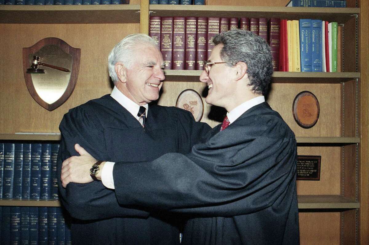 In this Oct. 13, 1989 photo, retired Judge Joseph A. Wapner of TV’s ‘The People’s Court’ congratulates his son, Judge Frederick N. Wapner, right, as he was enrobed as a Municipal Court judge in Los Angeles. Wapner, who presided over “The People’s Court” with steady force during the heyday of the reality courtroom show, has died. Wapner died at home in his sleep on Feb. 26, 2017, according to his son, David Wapner.