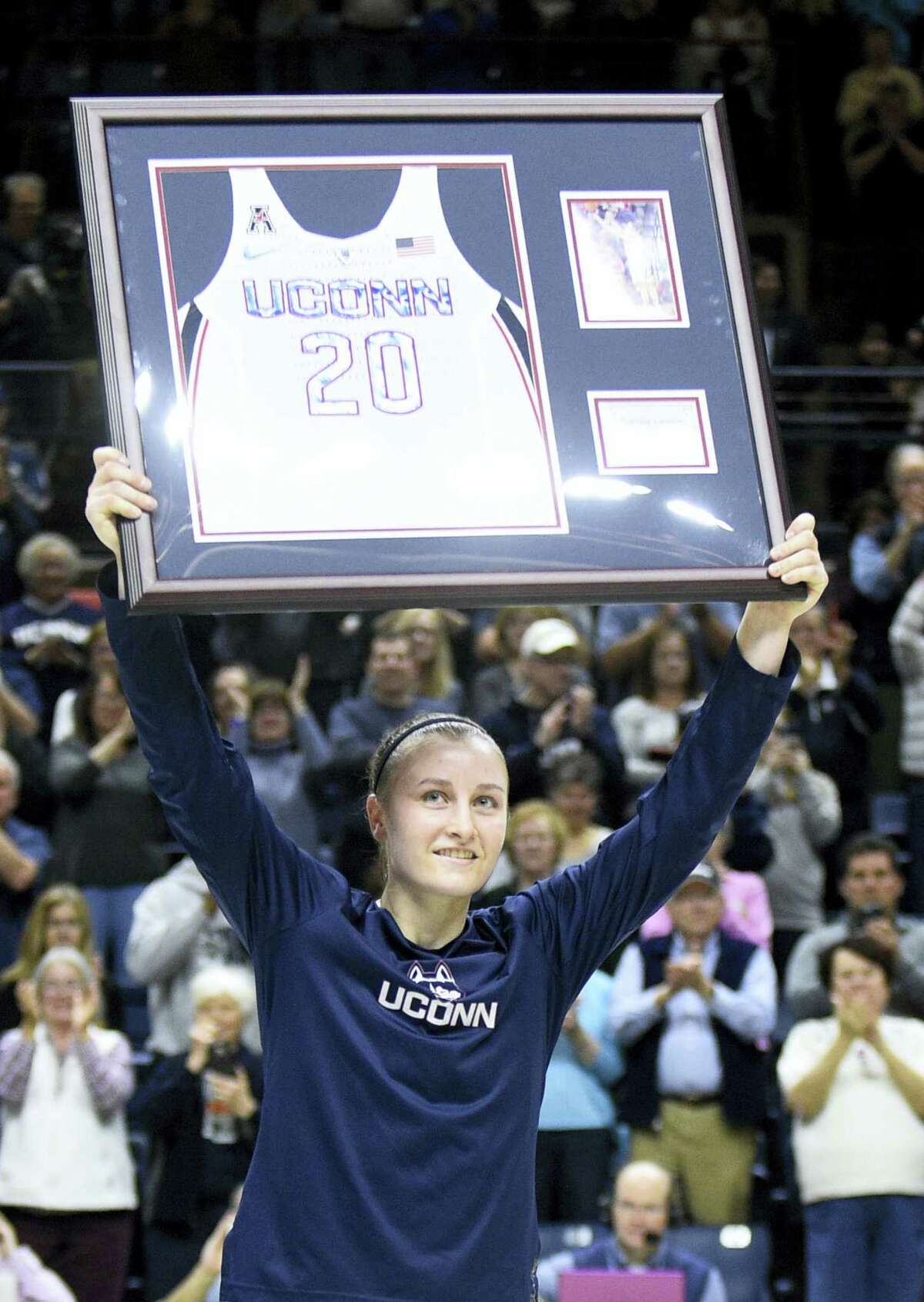 UConn’s Tierney Lawlor holds aloft a plague with her jersey number on Saturday.