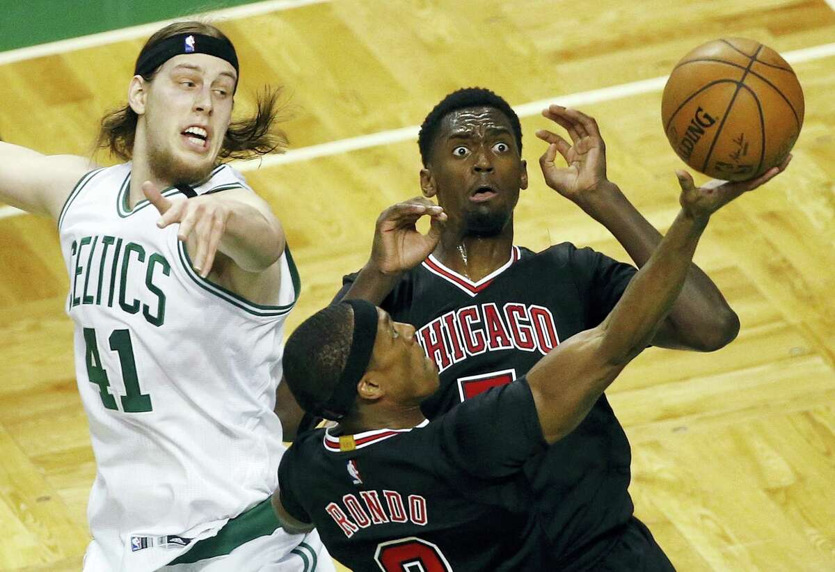 The Bulls’ Rajon Rondo (9) goes up to shoot in front of teammate Bobby Portis and the Celtics’ Kelly Olynyk during the second quarter Sunday in Boston.