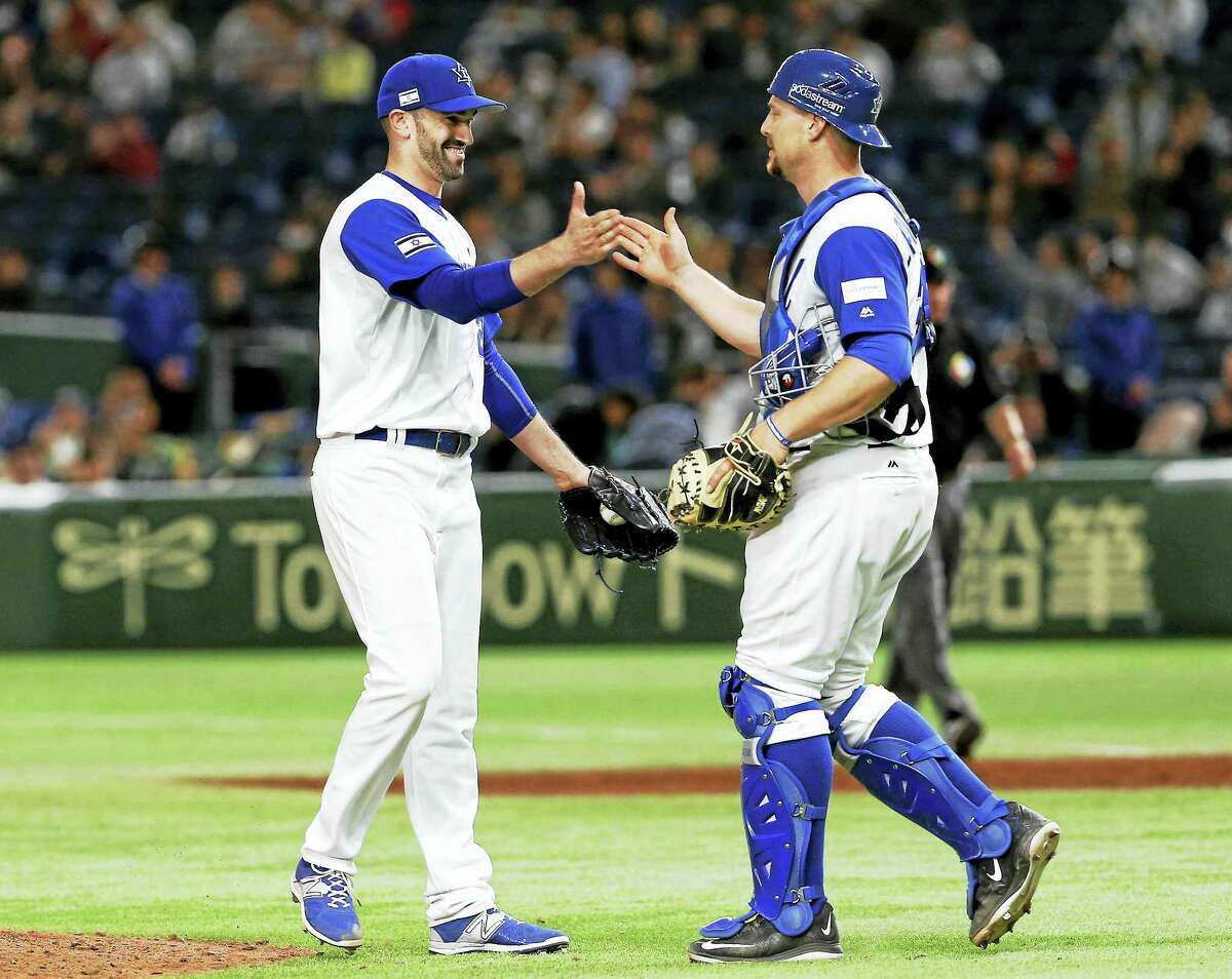 Josh Zeid, left, celebrates with catcher Ryan Lavarnway after a Team Israel win in the World Baseball Classic.