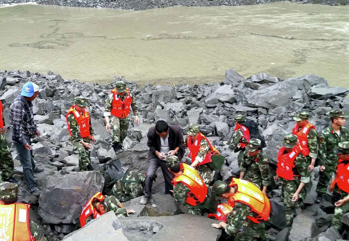Emergency personnel and locals work at the site of a landslide in Xinmo village in Maoxian County in southwestern China’s Sichuan Province, Saturday, June 24, 2017. Dozens of people are feared buried by a landslide that unleashed huge rocks and a mass of earth that crashed into their homes in southwestern China early Saturday, a county government said.