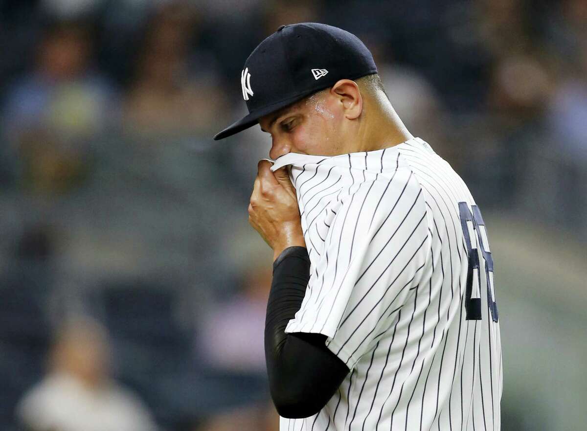Yankees relief pitcher Dellin Betances wipes his face on his jersey while leaving the mound after allowing two runs in the seventh inning Thursday.
