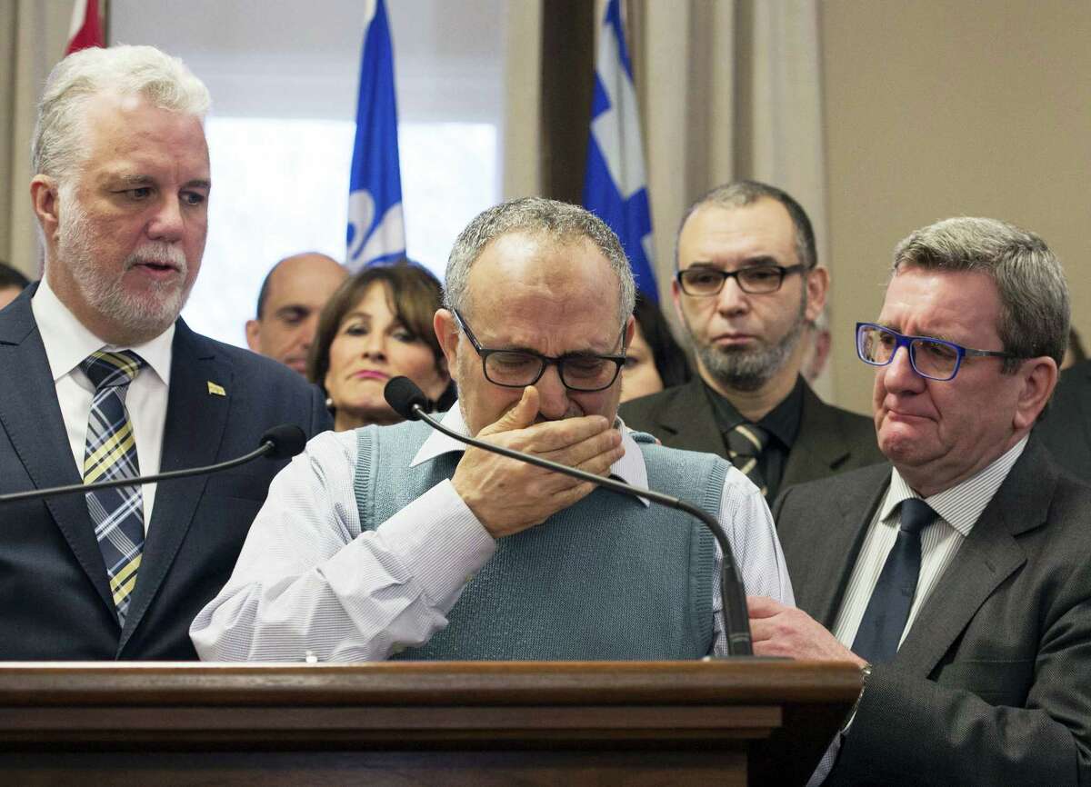 CORRECTS NAME AND TITLE TO LABIDI FROM LABIBI AND VICE PRESIDENT FROM PRESIDENT - Mohamed Labidi, the vice-president of the mosque where an attack happened, is comforted by Quebec Premier Philippe Couillard, left, and Quebec City mayor Regis Labeaume, right, during a news conference Monday about the fatal shooting at the Quebec Islamic Cultural Centre on Sunday. Prime Minister Justin Trudeau and Couillard both characterized the attack at the mosque during evening prayers as a terrorist act.