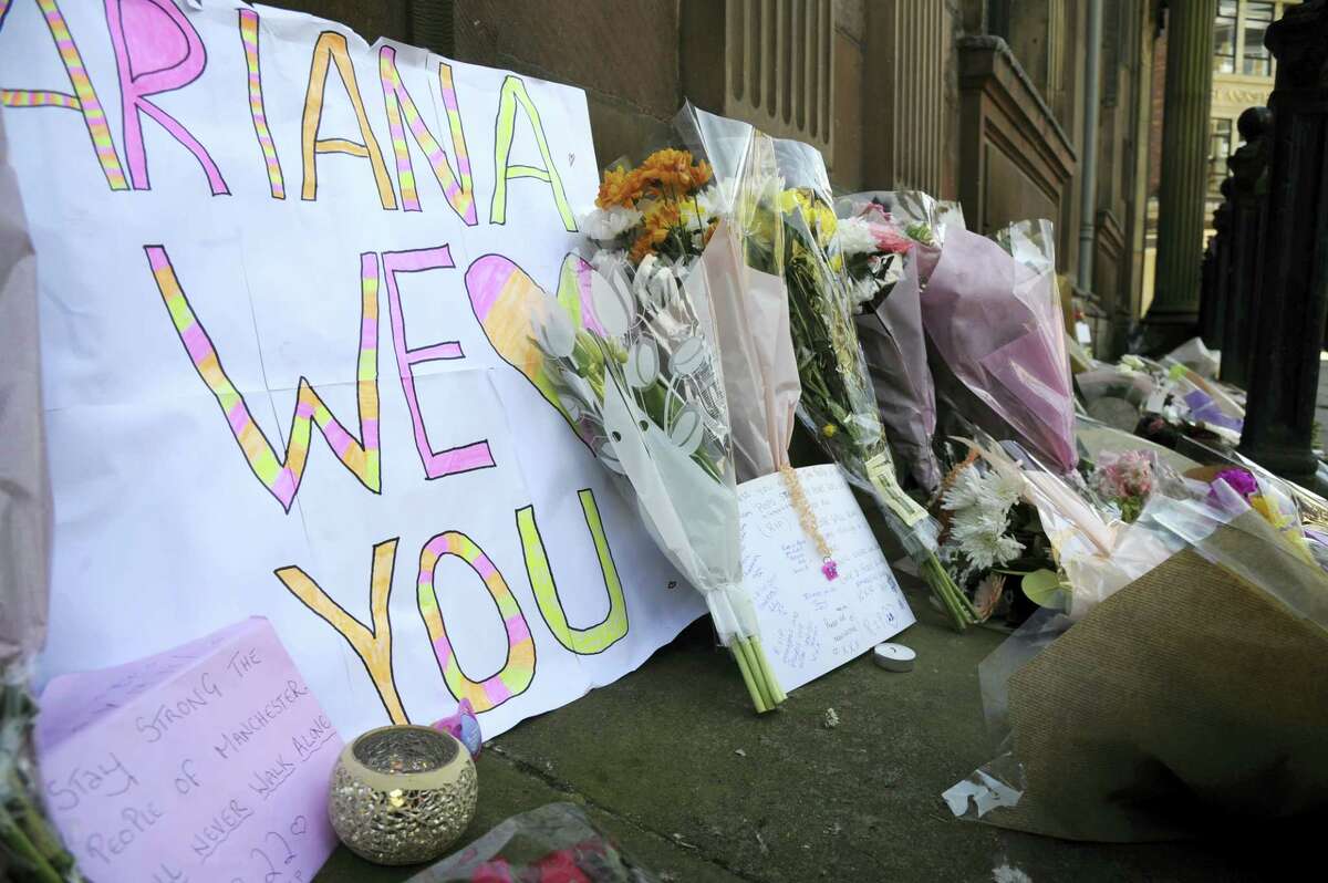 Flower tributes at St Ann’s square, Manchester, England Tuesday May 23, 2017. The Islamic State group claimed responsibility Tuesday for the suicide attack at an Ariana Grande show that left more than 20 people dead as young concertgoers fled, some still wearing the American pop star’s trademark kitten ears and holding pink balloons.
