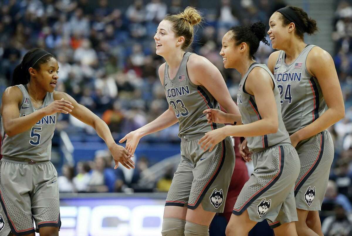 Connecticut’s Crystal Dangerfield, Katie Lou Samuelson, Saniya Chong and Napheesa Collier, from left, celebrate as they come off the court for a timeout in the second half of an NCAA college basketball game against Temple, Wednesday in Hartford, Conn.