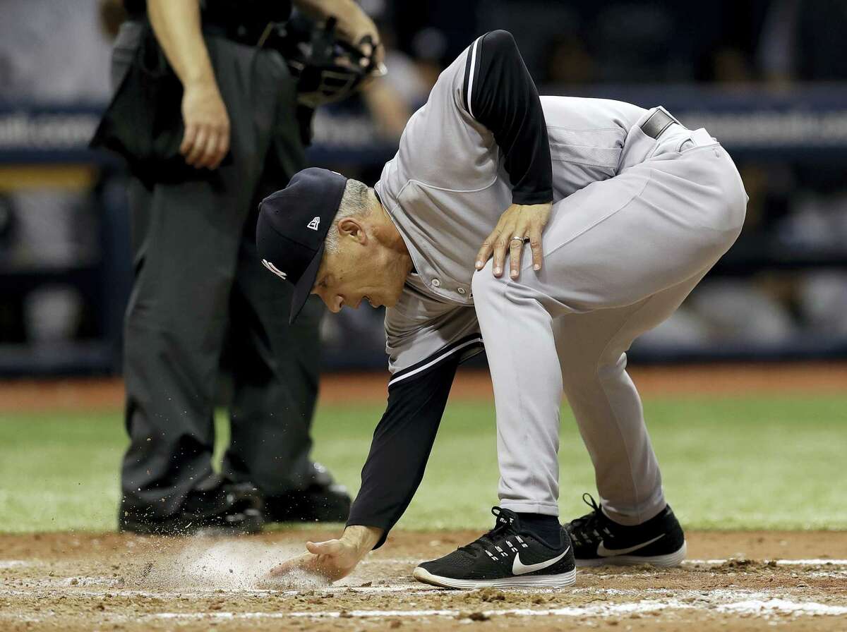 Yankees manager Joe Girardi covers home plate with dirt after being ejected along with pitching coach Larry Rothschild in the fifth inning Saturday.