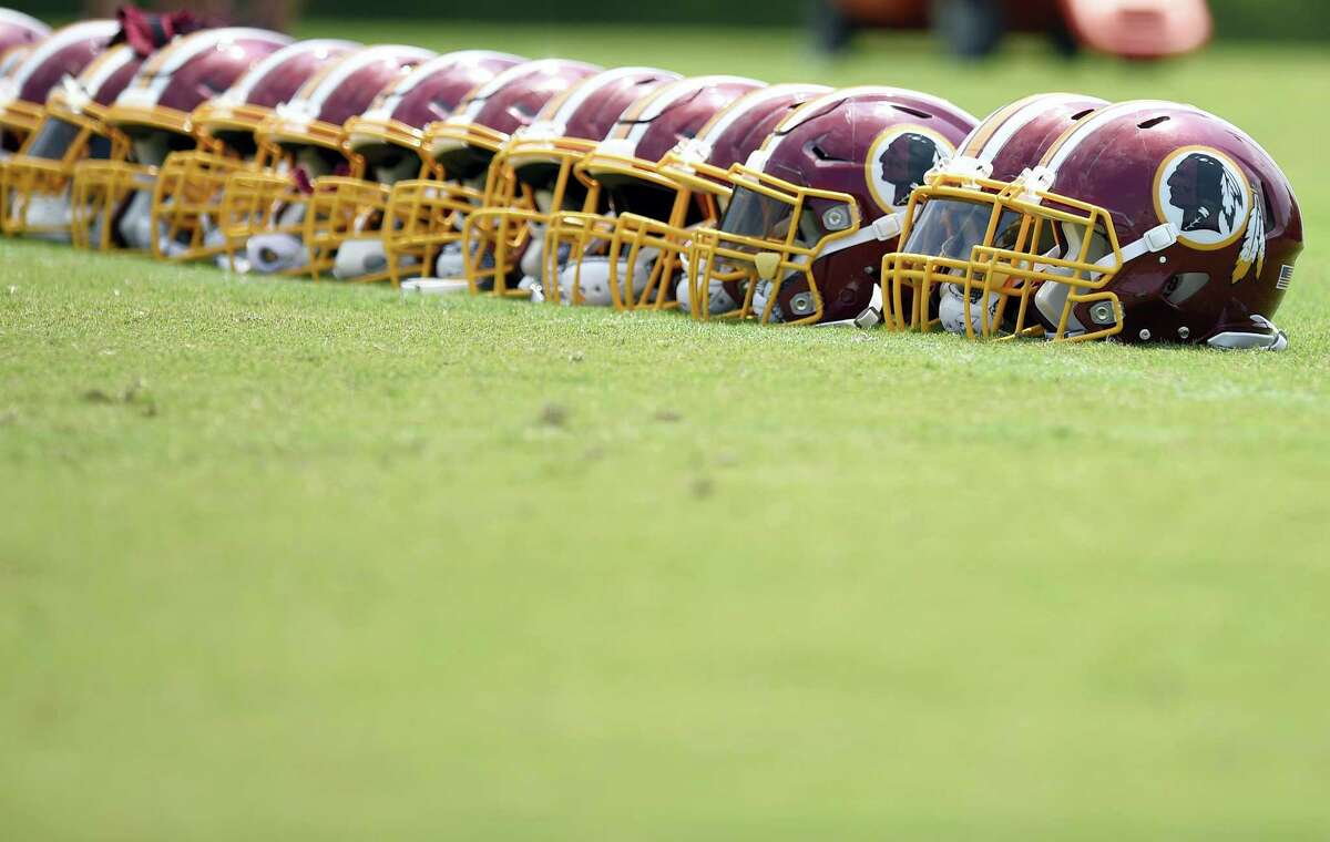 Washington Redskins football helmets are seen on the field during an NFL football team practice, Wednesday, June 14, 2017, in Ashburn, Va.