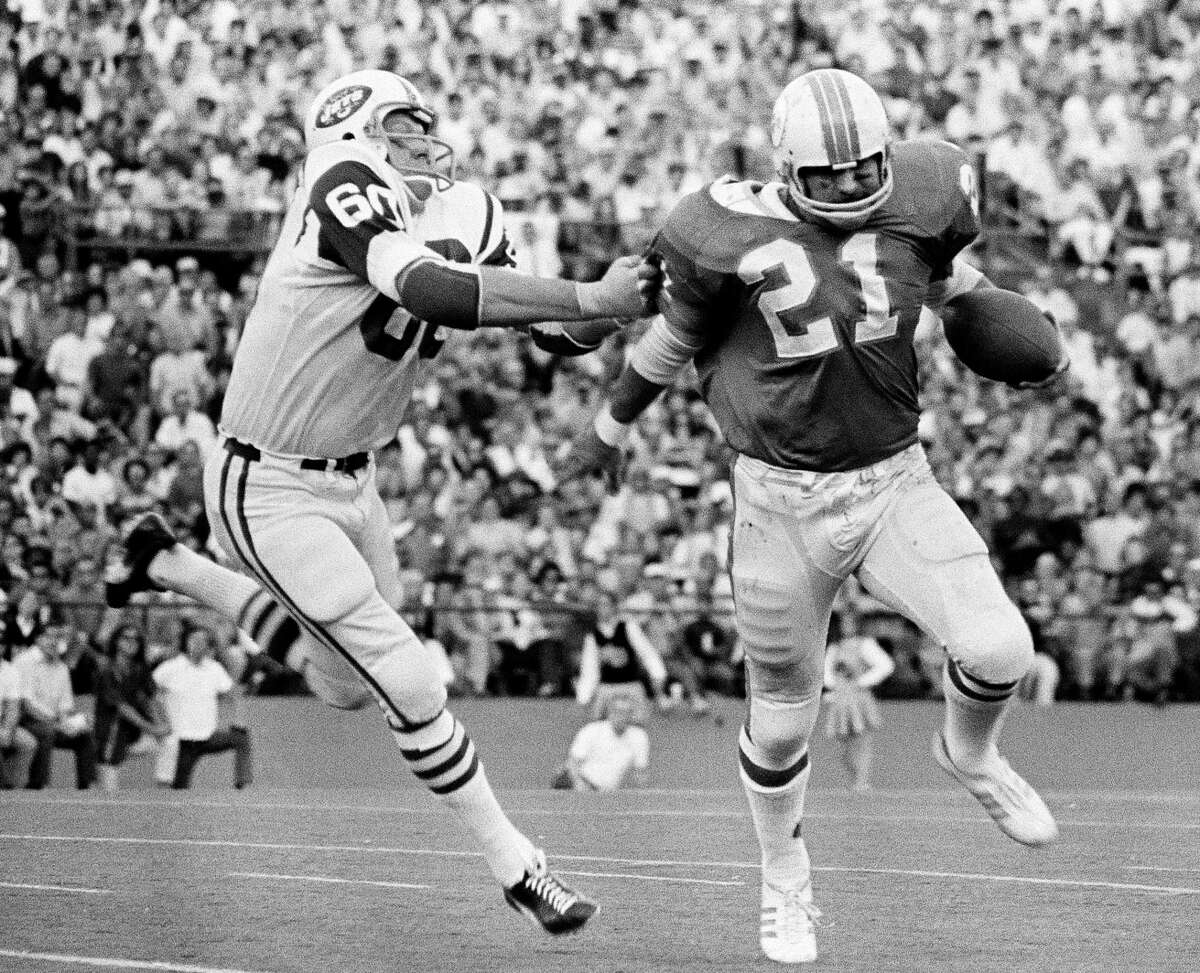 New York Jets linebacker Larry Grantham (60) catches Miami Dolphins back Jim Kiick (21), by the sleeve to throw him for a one-yard loss.