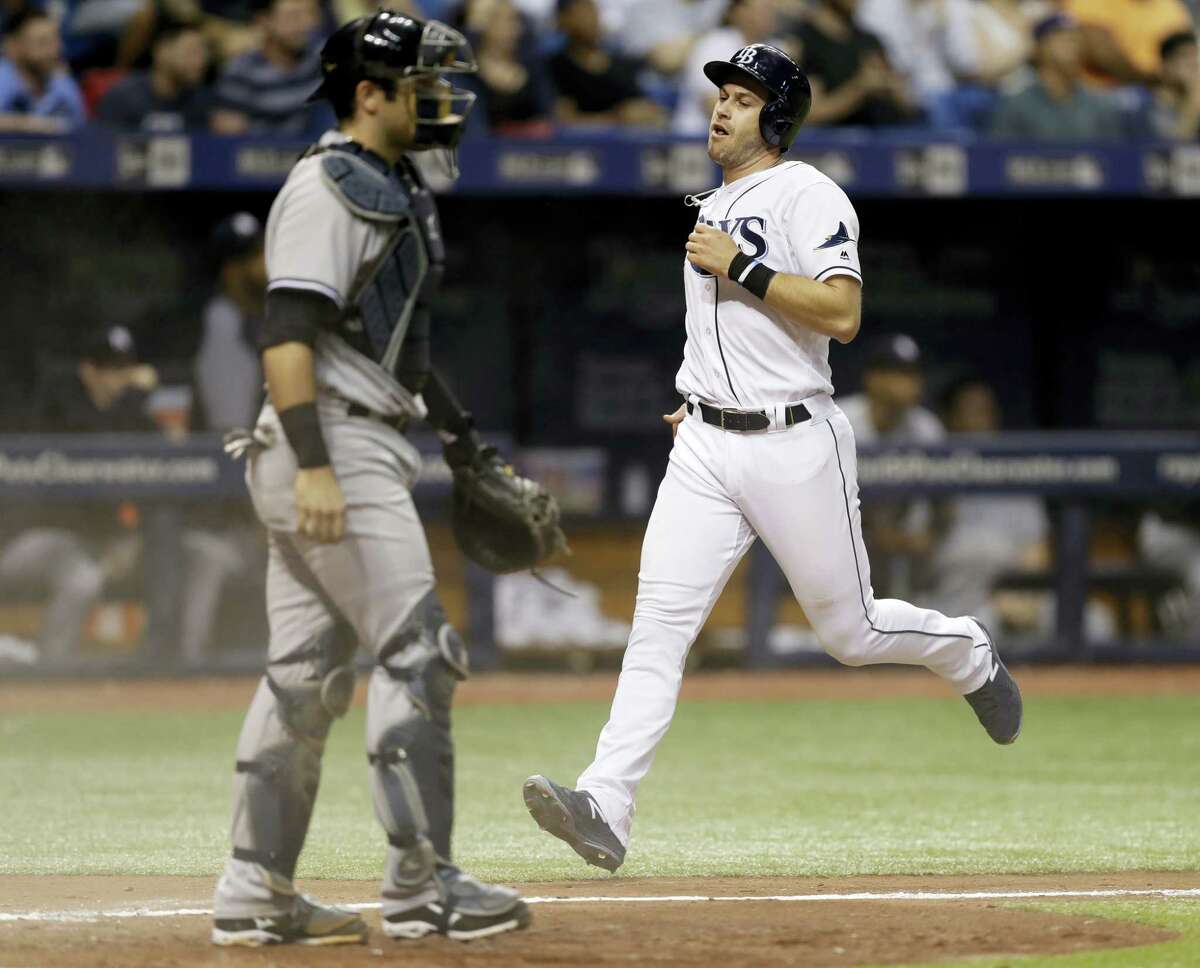 The Rays’ Evan Longoria, right, scores in the seventh inning on Friday.