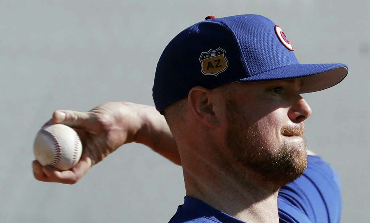 Chicago Cubs’ Jon Lester throws during a spring training baseball workout on Feb. 14, 2017 in Mesa, Ariz.