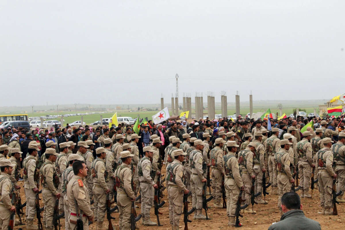 This photo provided by Hawar News Agency, a Kurdish-run news agency, which has been authenticated based on its contents and other AP reporting, shows fighters from the predominantly-Kurdish Syrian Democratic Forces attending the funeral procession of 18 of their comrades, who were killed Tuesday by a misdirected airstrike by the U.S.-led coalition, in Tal al-Abyad, northeast Syria, Thursday, April 13, 2017. U.S. Central Command said coalition aircraft were given the wrong coordinates by their partner forces, the Syrian Democratic Forces, for a strike intended to target Islamic State militants south of their Tabqa stronghold. (Hawar News Agency via AP)