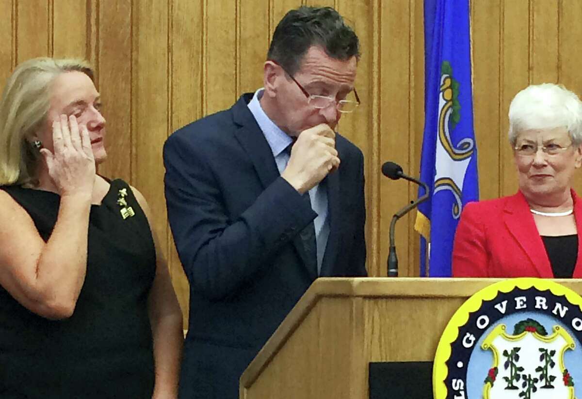 Connecticut Gov. Dannel P. Malloy pauses after announcing Thursday, April 13, 2017, at the Capitol in Hartford, Conn., that he will not seek a third term in 2018. He is flanked by his wife, Cathy, left, and Lt. Gov. Nancy Wyman, right. (AP Photo/Susan Haigh)