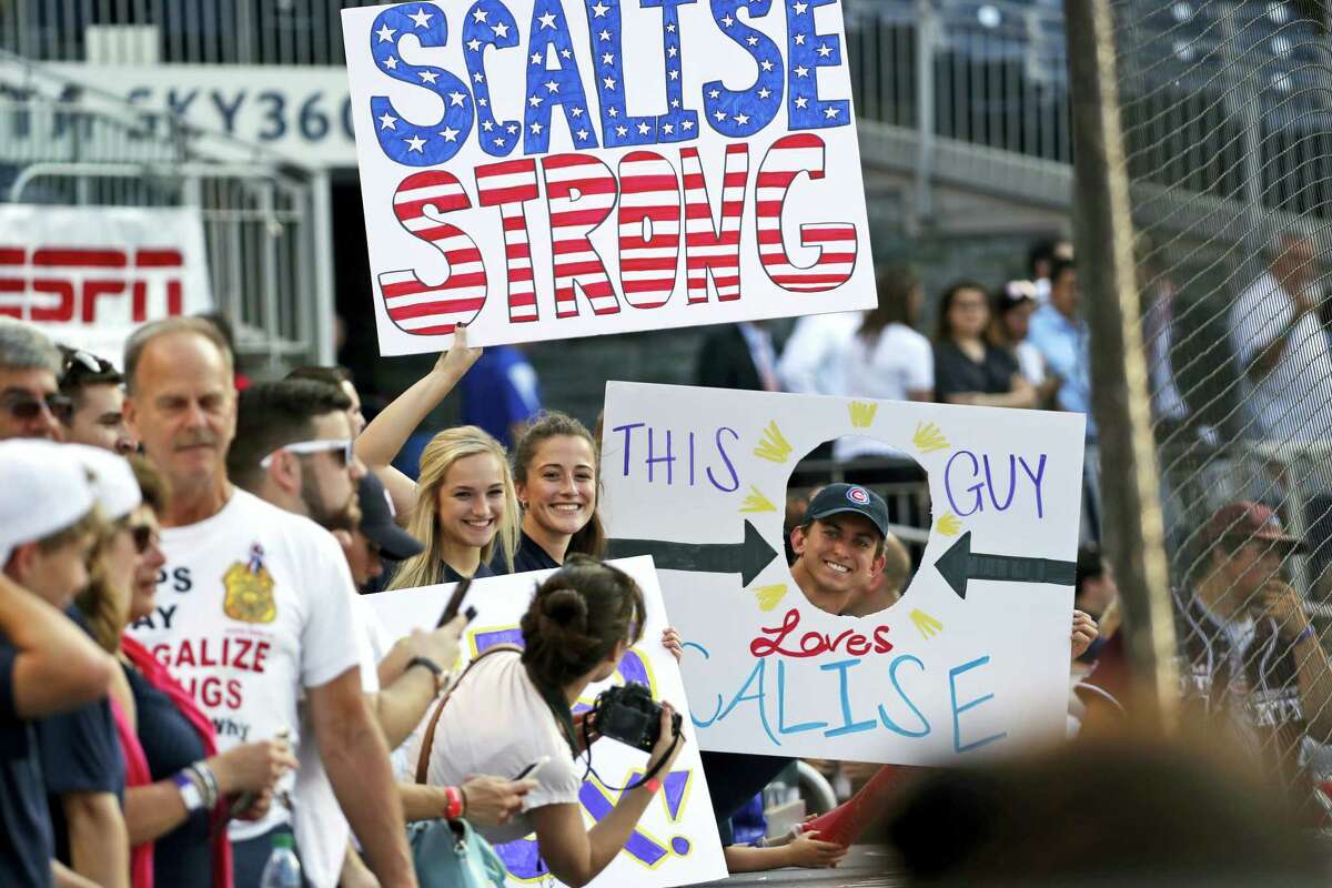 Supporters of House Majority Whip Steve Scalise, R-La., hold signs before the Congressional baseball game.