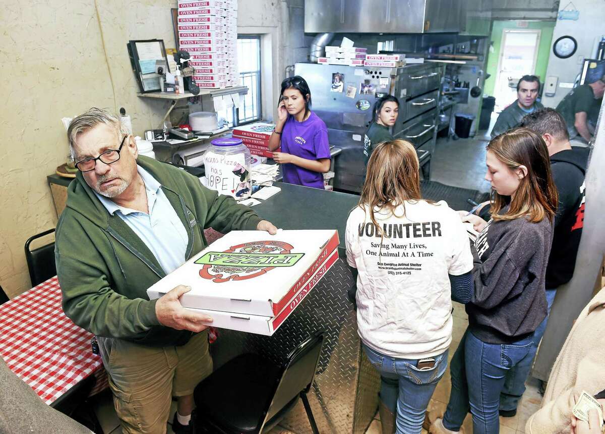(Arnold Gold-New Haven Register) George Wolcheski (left) of East Haven leaves Frisco’s Pizza in New Haven on 3/19/2017 with some pizza to go during a fundraiser for the dog, Hope, being cared for at the Dan Cosgrove Animal Shelter in Branford.