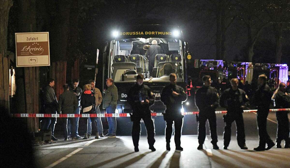 Police officers stand in front of Dortmund’s damaged team bus after an explosion before the Champions League quarterfinal soccer match between Borussia Dortmund and AS Monaco in Dortmund, western Germany, Tuesday.