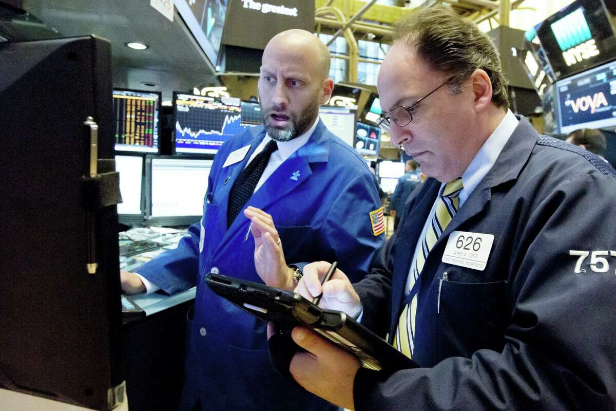 Specialist Meric Greenbaum, left, and trader James Conti work on the floor of the New York Stock Exchange Wednesday.