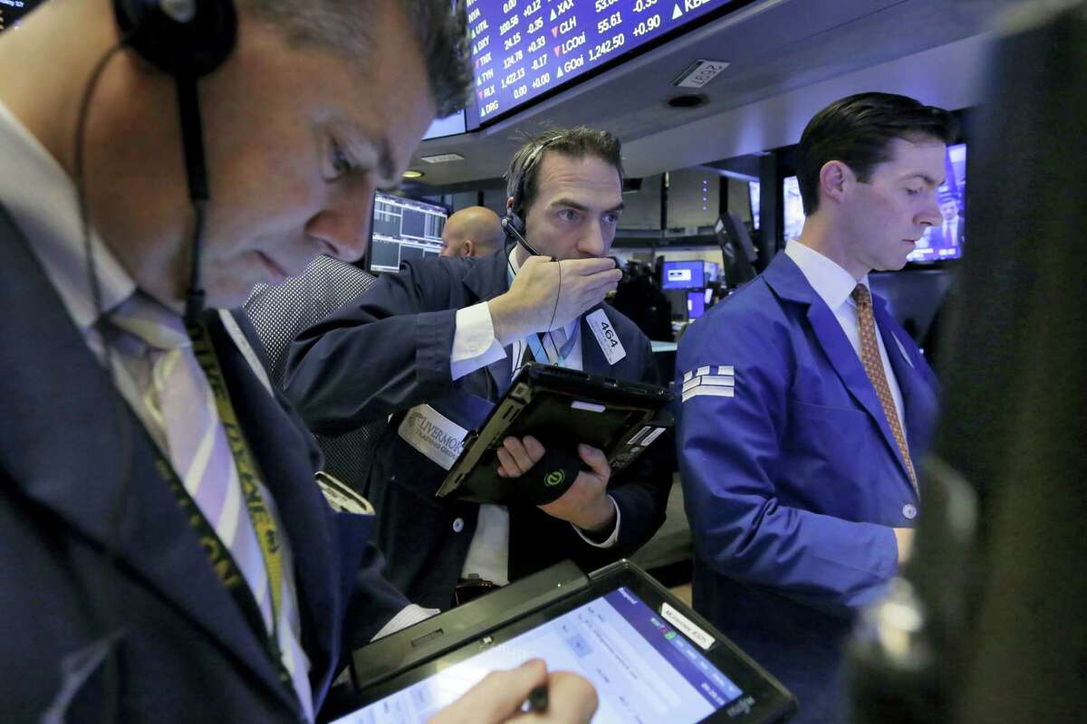 Trader Gregory Rowe, center, works on the floor of the New York Stock Exchange Friday.