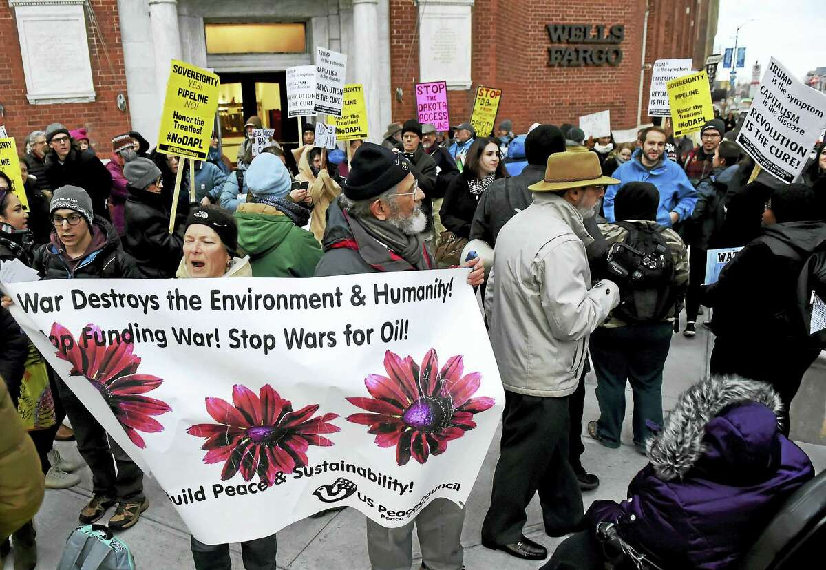 Protesters demonstrate in front of the Wells Fargo bank branch on the corner of College and Elm Streets in New Haven Friday against the Dakota Access Pipeline project.