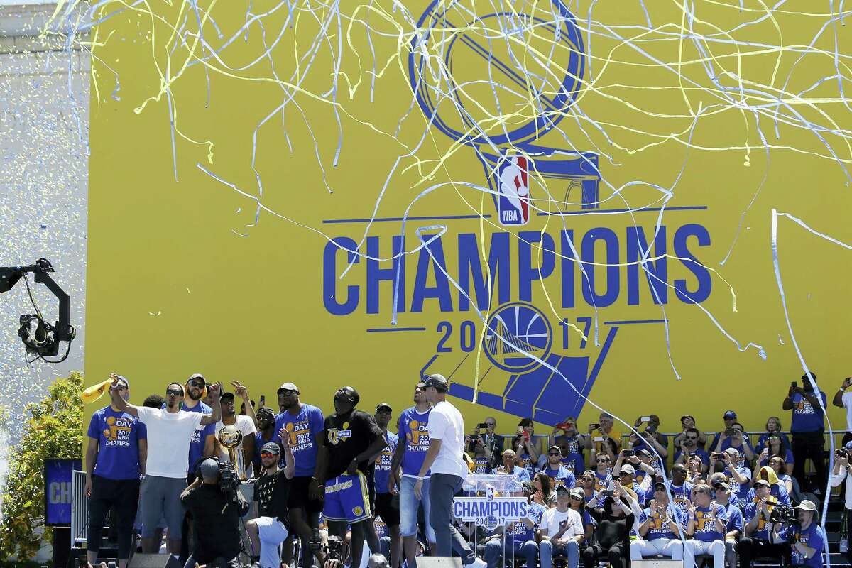 The Golden State Warriors celebrate at the conclusion of their NBA championship rally Thursday in Oakland.