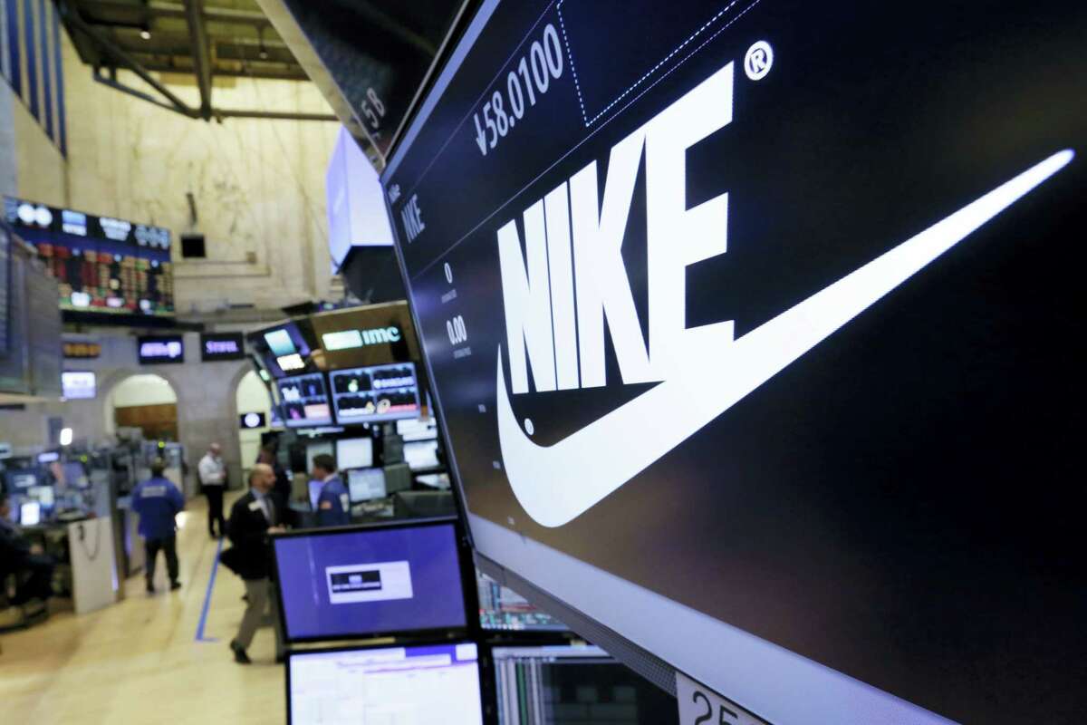The Nike logo appears above the post where it trades on the floor of the New York Stock Exchange.