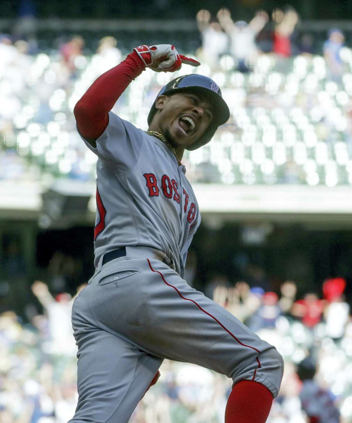 Mookie Betts reacts as he rounds first after hitting a home run in the ninth inning.
