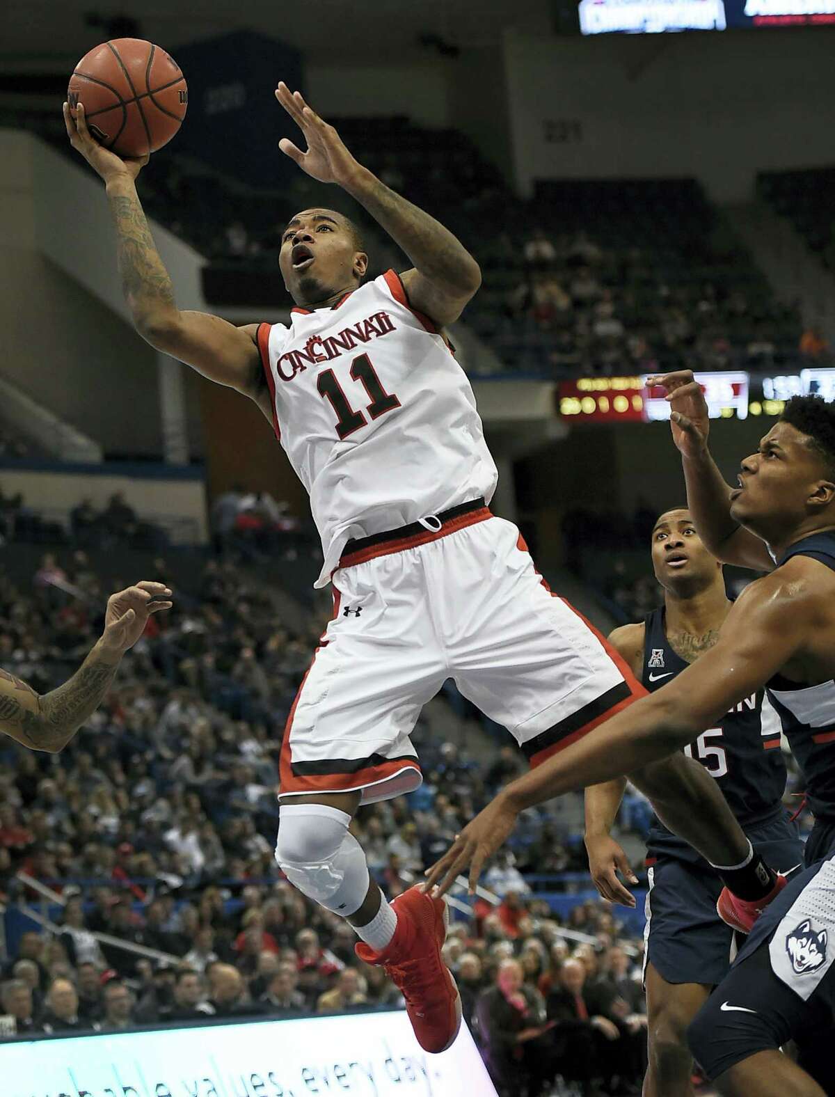 Cincinnati’s Gary Clark, shoots as UConn’s Vance Jackson, right, defends during the first half Saturday.